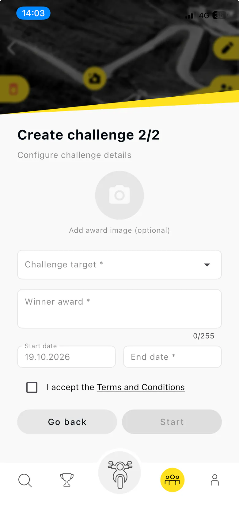 Old Create challenge screen, step 2 of 2: a blurred road header cut by a yellow diagonal, an optional award image, a Challenge target dropdown, a Winner award field, start and end dates, a Terms and Conditions checkbox, and Go back and Start buttons.